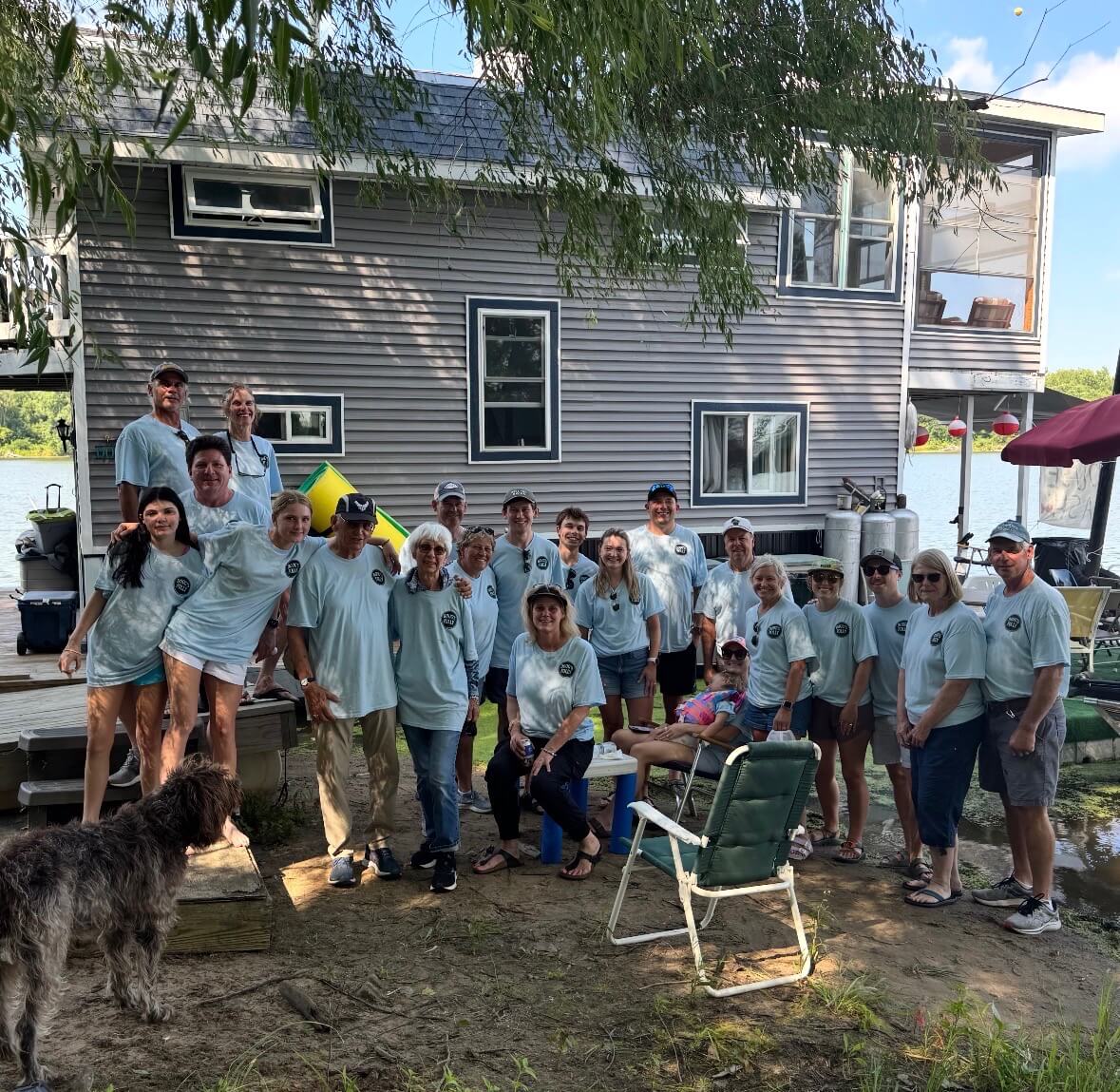 Group of volunteers in matching T-shirts outside a house
